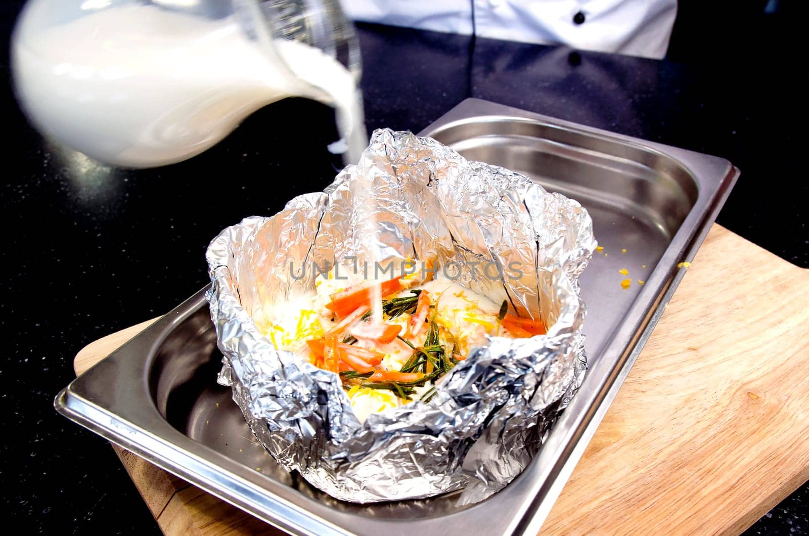 Meat with vegetables in foil on Protvino. Wooden background.