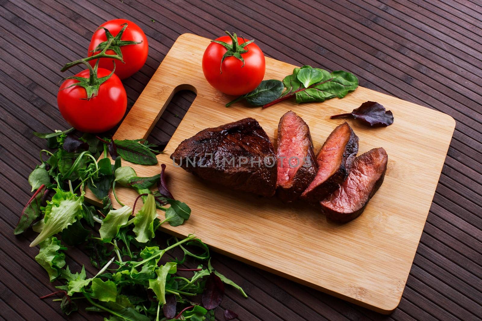 Close-up of Medium Rare Roast Beef with Fresh Herbs and  Vegetables
