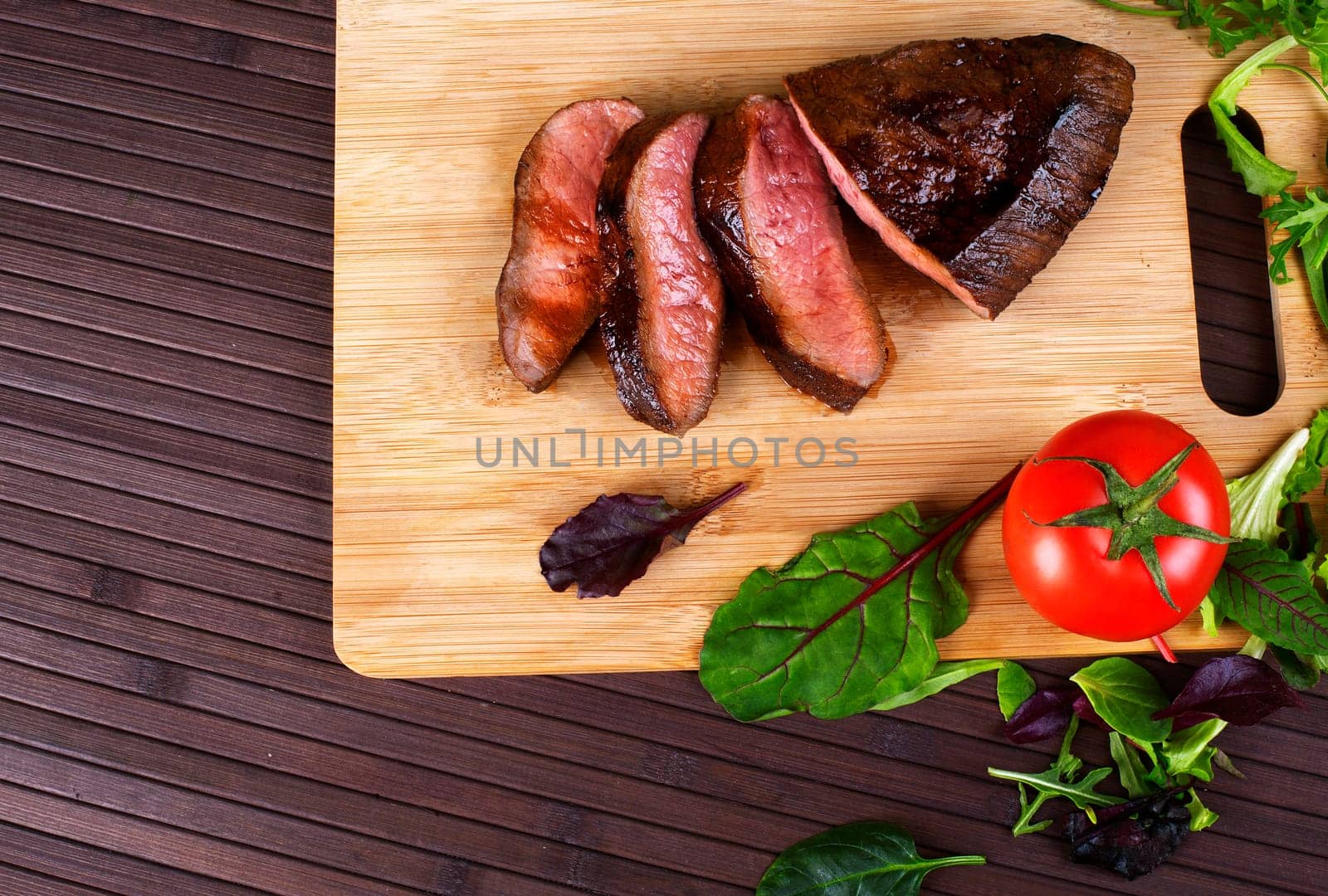 Close-up of Medium Rare Roast Beef with Fresh Herbs and  Vegetables