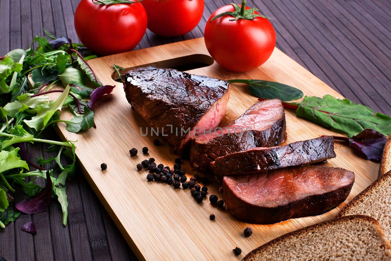 Close-up of Medium Rare Roast Beef with Fresh Herbs and  Vegetables