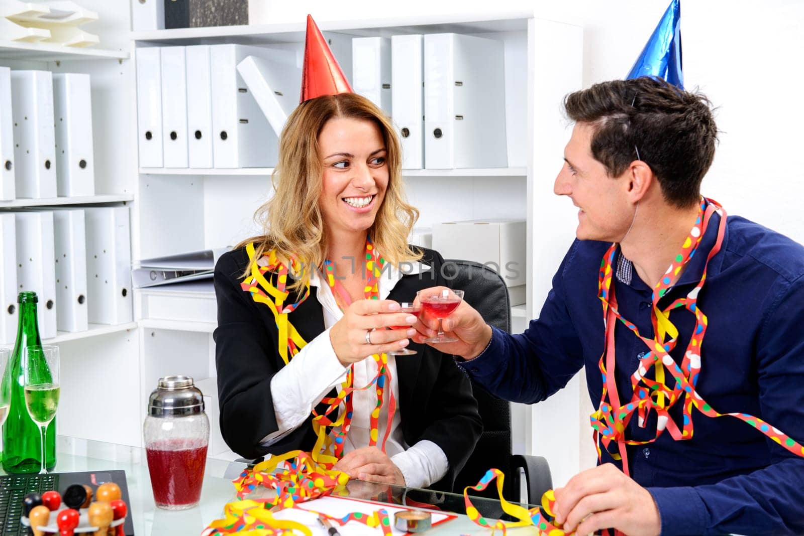 young businessman and businesswoman celebrating together in the office
