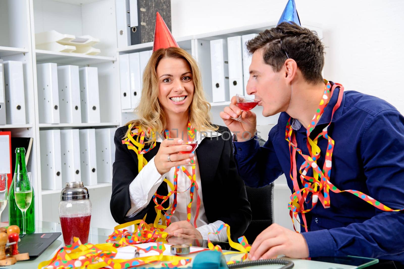 young businessman and businesswoman celebrating together in the office