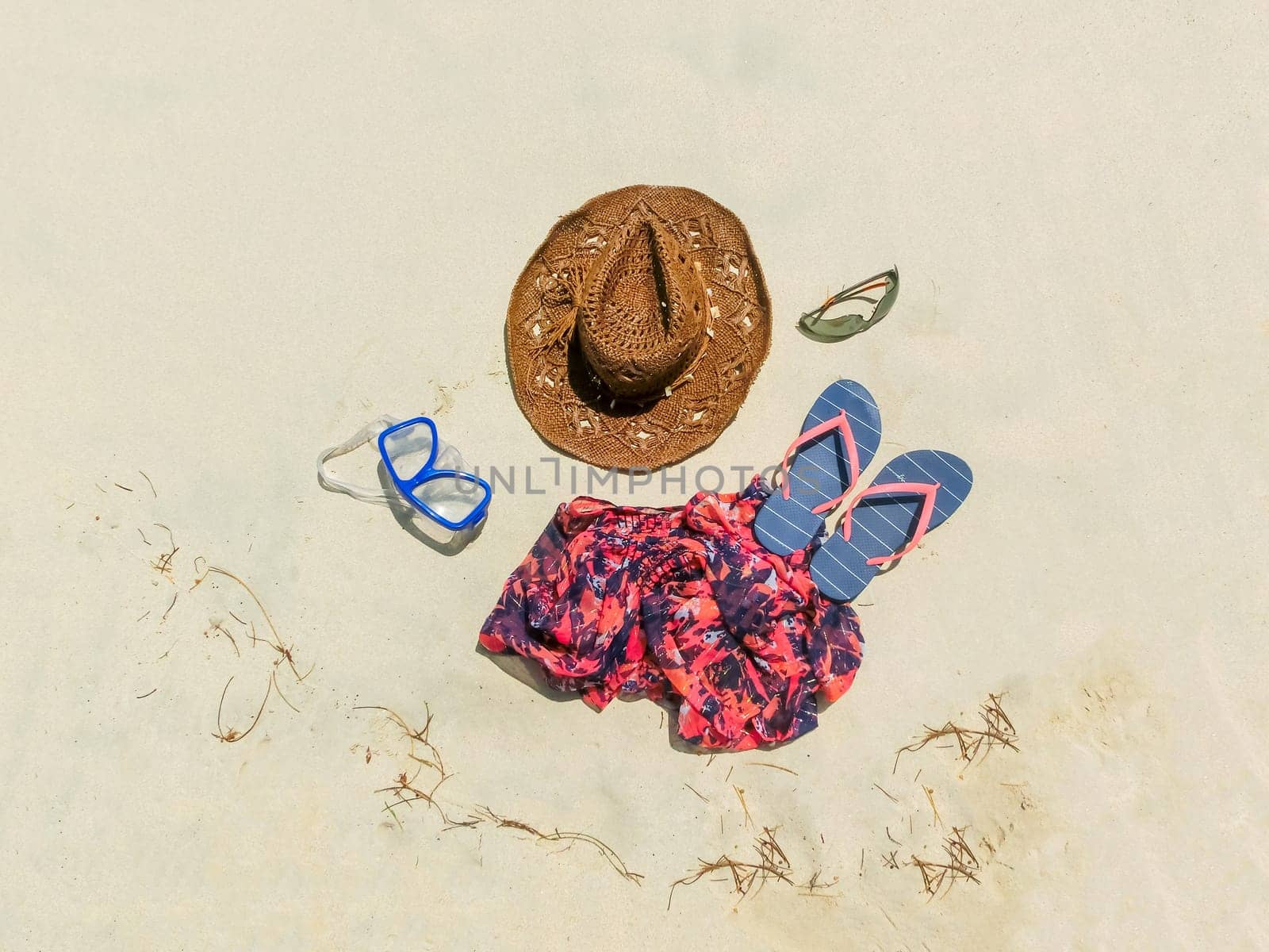 The straw hat, mask, sun glasses and dress on a tropical beach