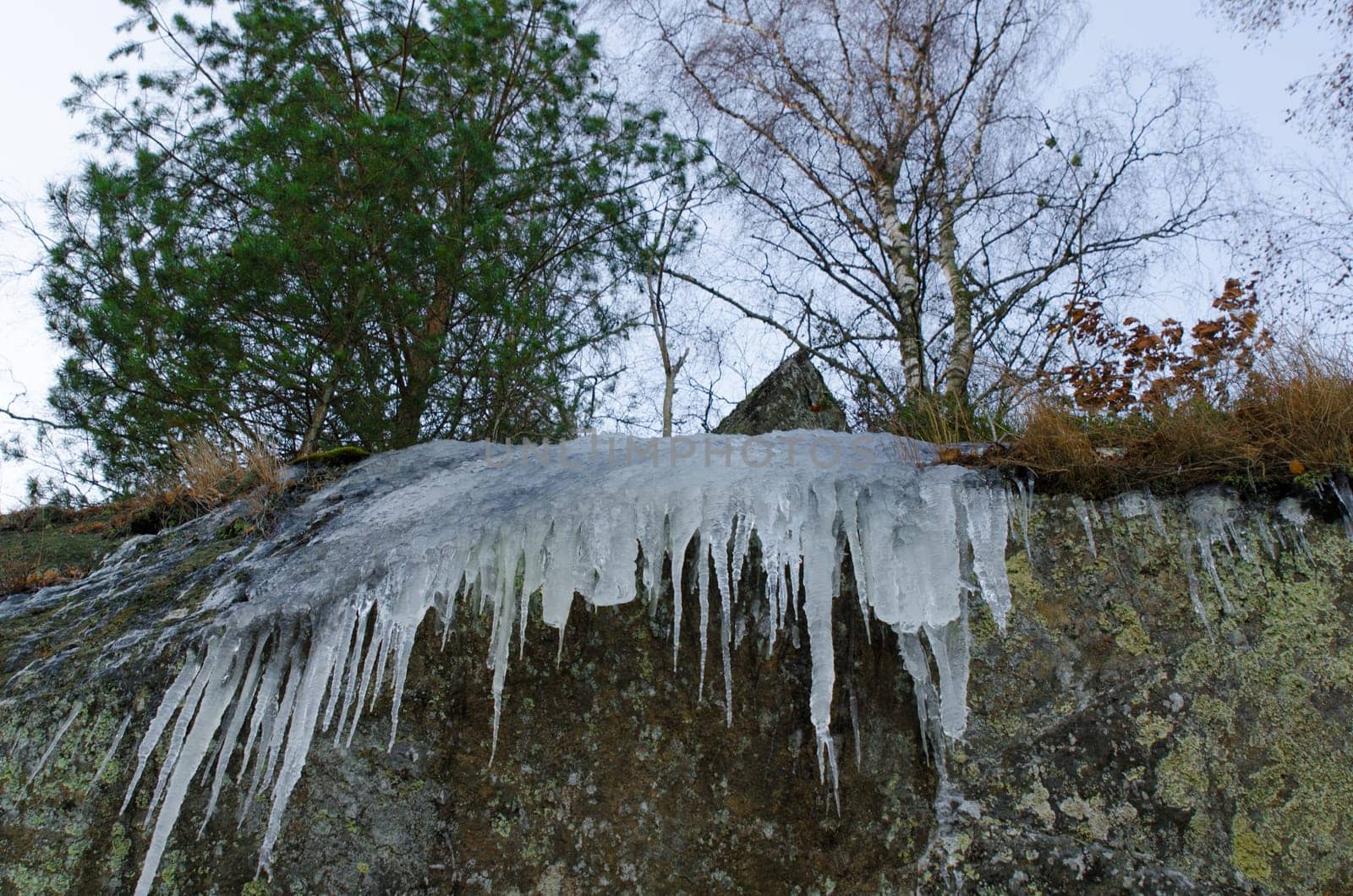 some icicless hanging down from the cliff and have start to drop