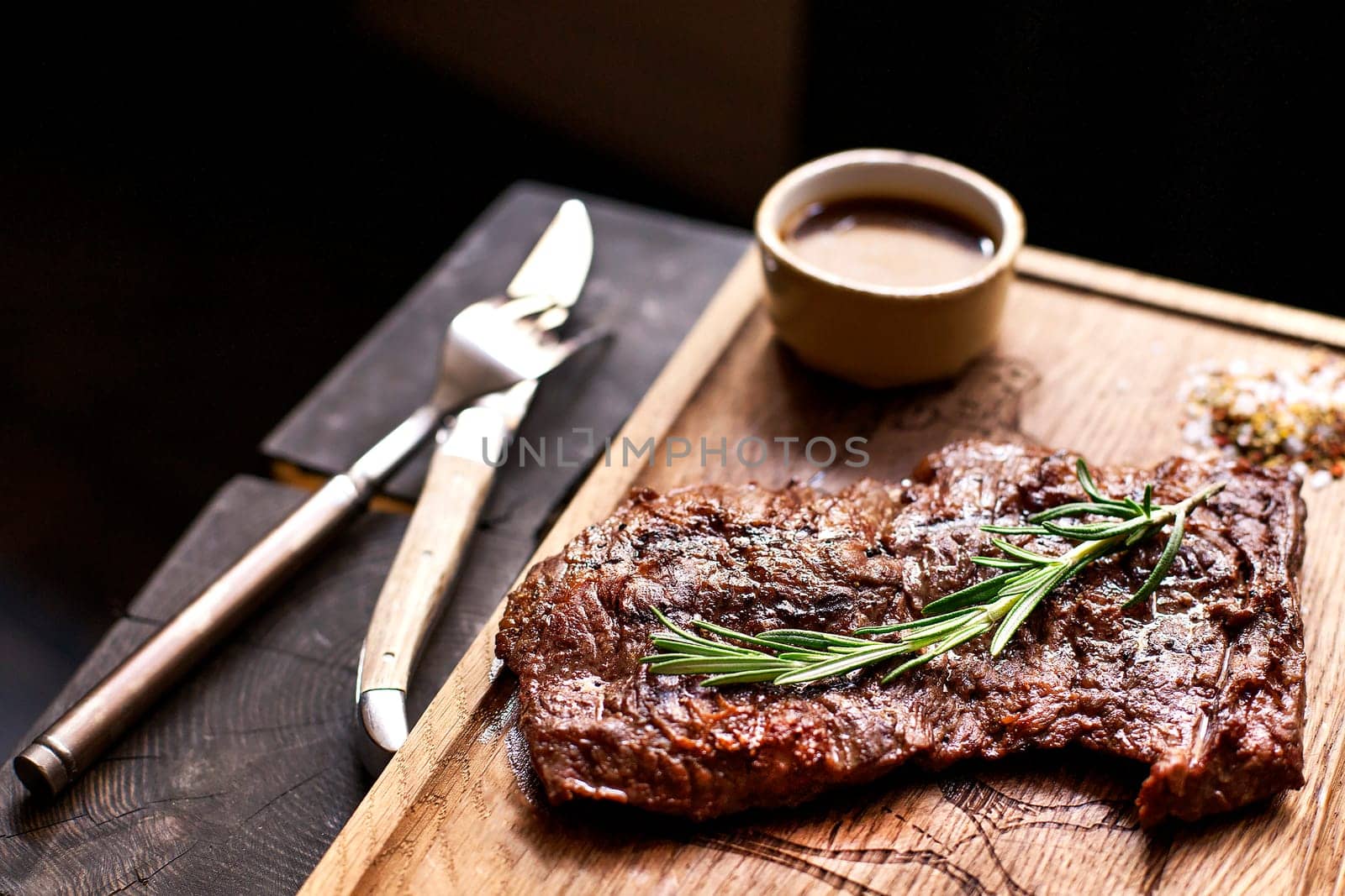Beef steak. Piece of  Grilled BBQ beef marinated in spices and herbs on a rustic wooden board over rough wooden desk with a copy space. Top view