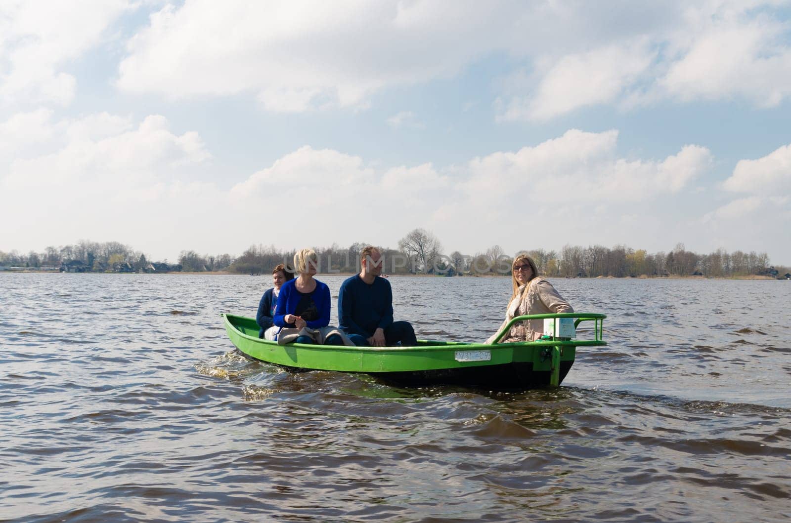 GIETHOORN, NETHERLANDS - APRIL 3, 2016: Unknown family enjoying their boating trip around Giethoorn, also called the Venice of the north
