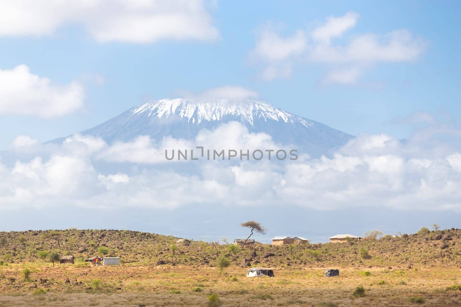Mount Kilimanjaro, Tanzania., the highest mountain in Africa. Traditional african savannah village in foreground.