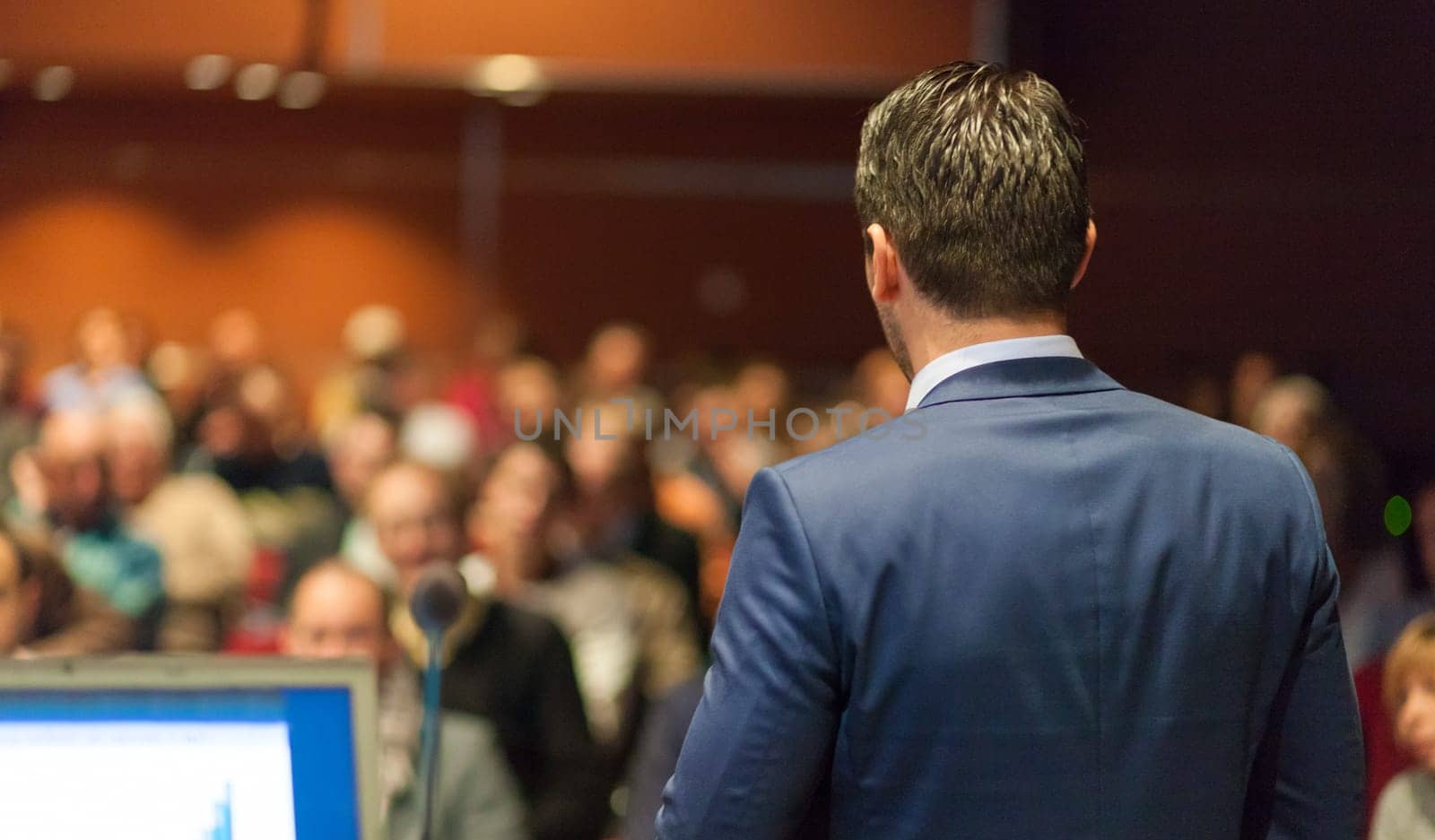 Speaker giving a talk on corporate Business Conference. Audience at the conference hall. Business and Entrepreneurship event.