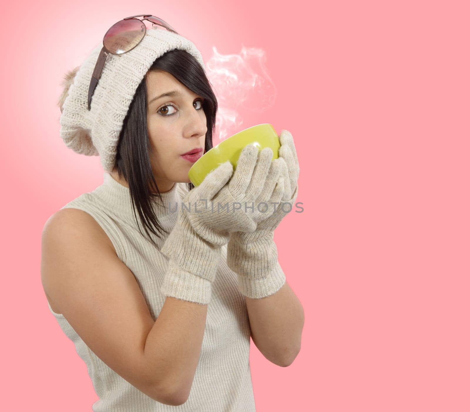 pretty young brunette woman with a cup of tea on pink background