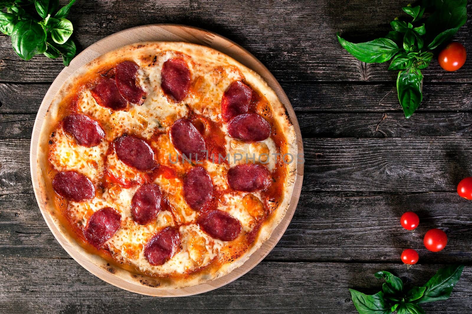 Delicious fresh Pepperoni pizza with salami and cheese on the wooden background. Top view.
