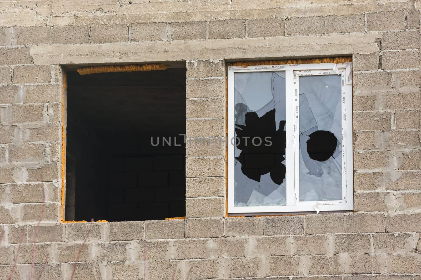Anapa, Russia - November 16, 2016: Two windows in an unfinished house - one without a frame and glass, the other broken glass