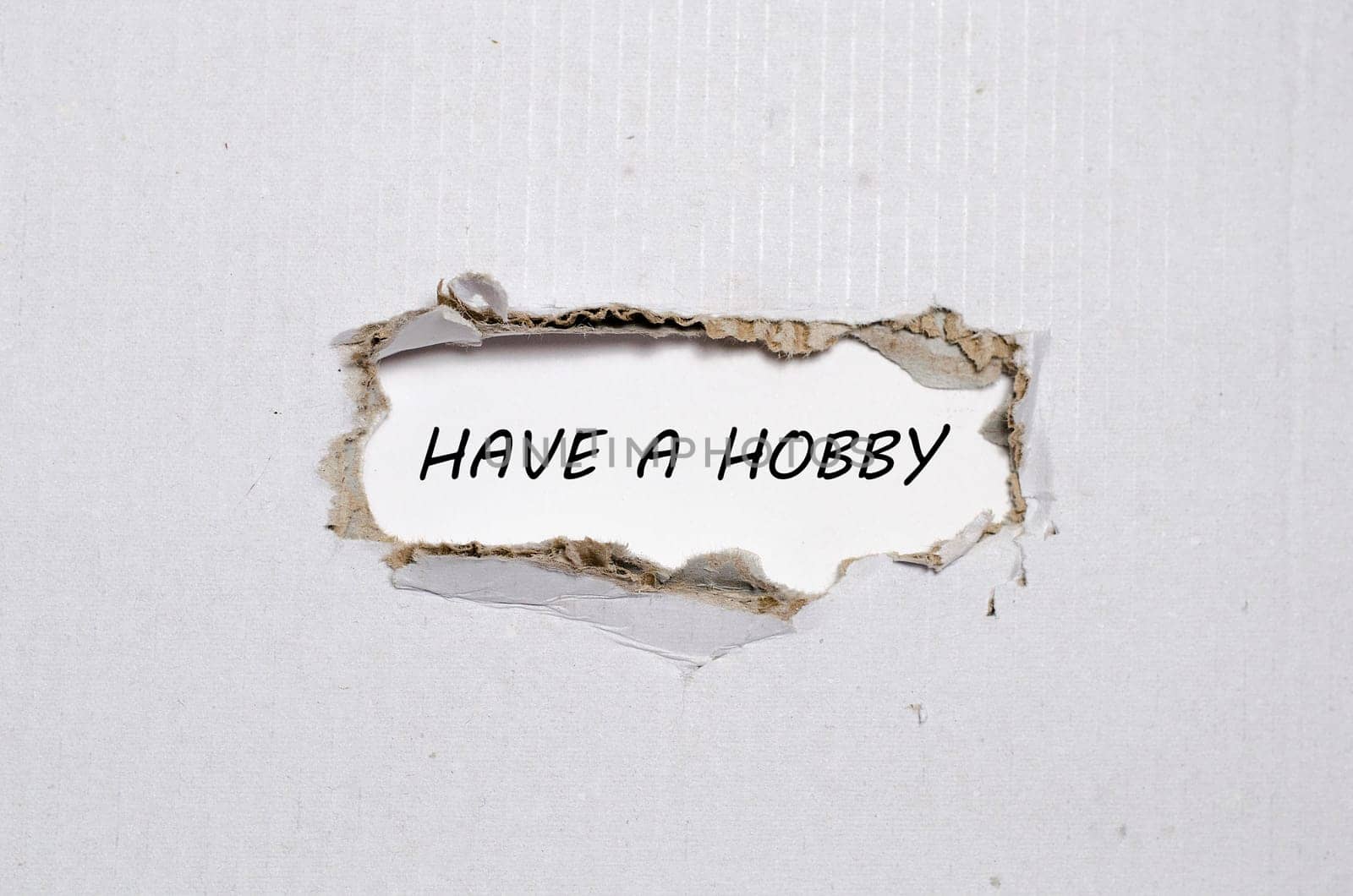 The word have a hobby appearing behind torn paper