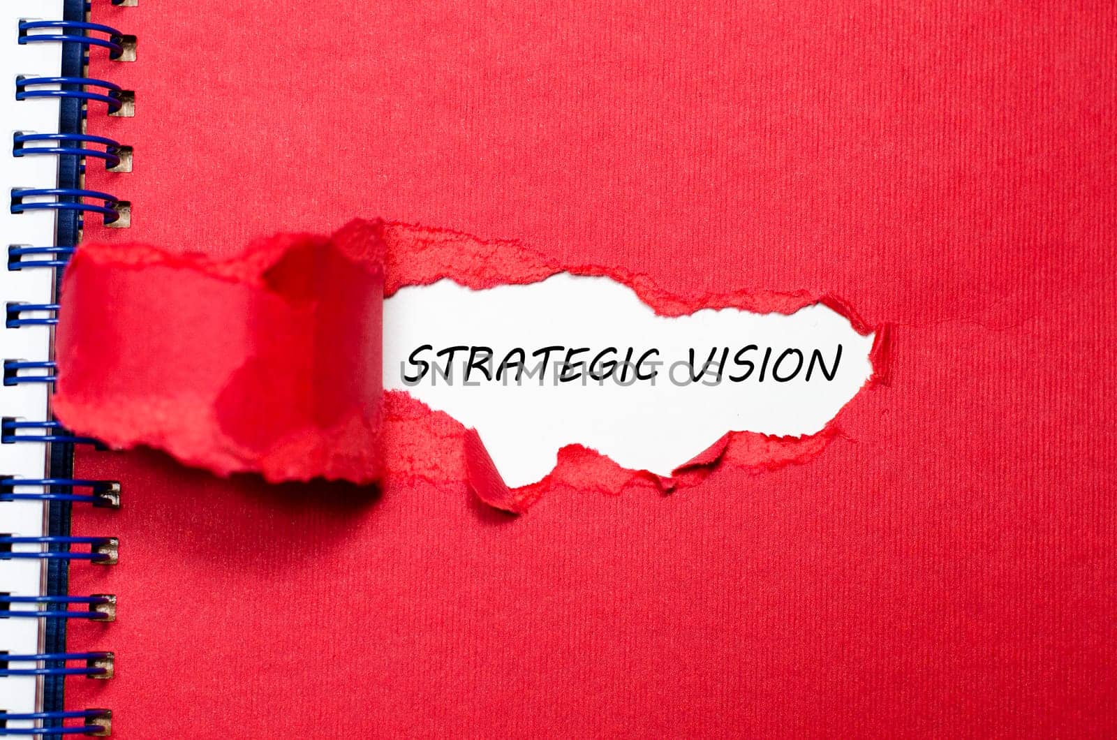 The word strategic vision appearing behind torn paper