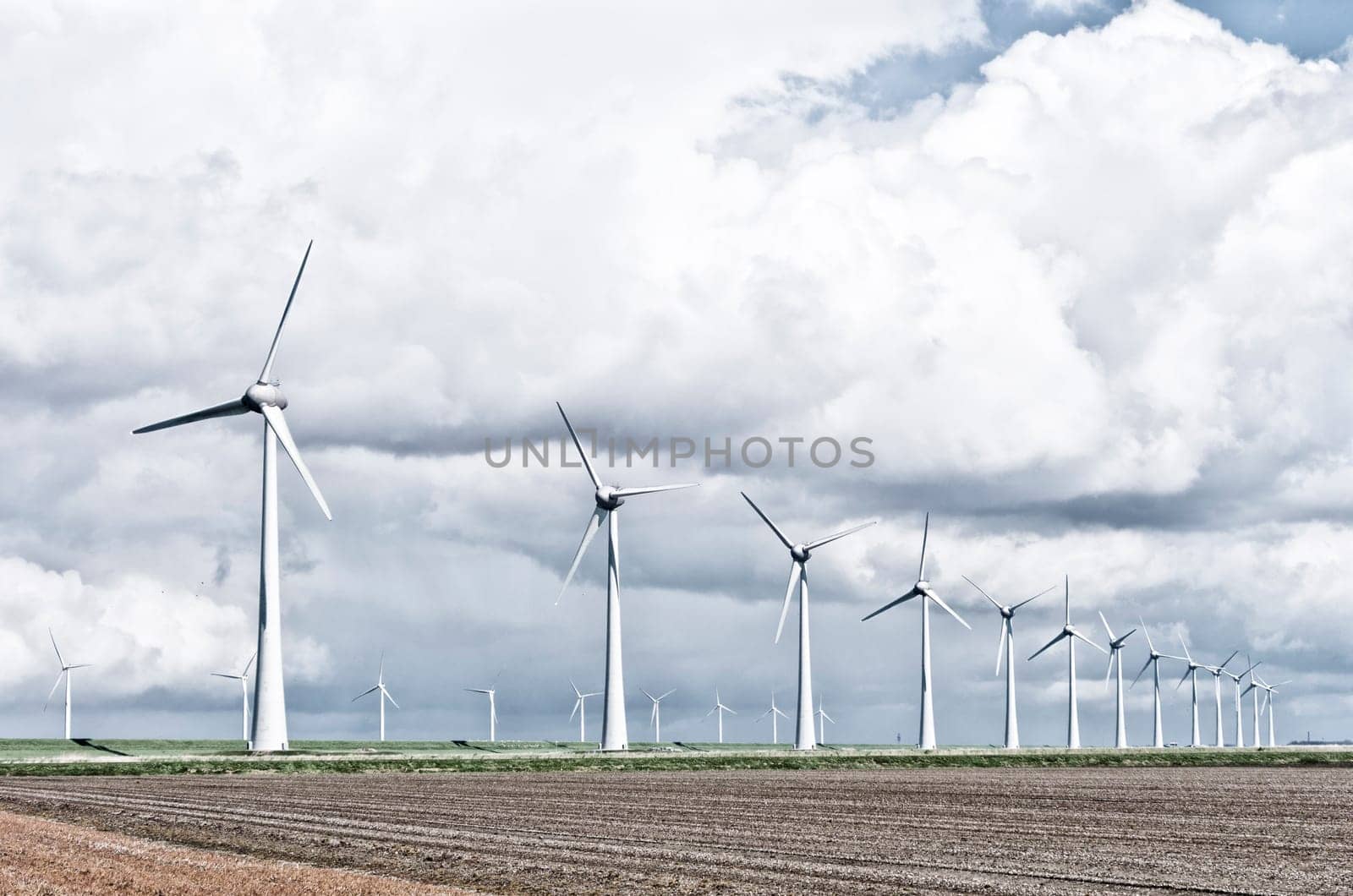 row wind turbines in an agricultural dutch landscape harsh filtered