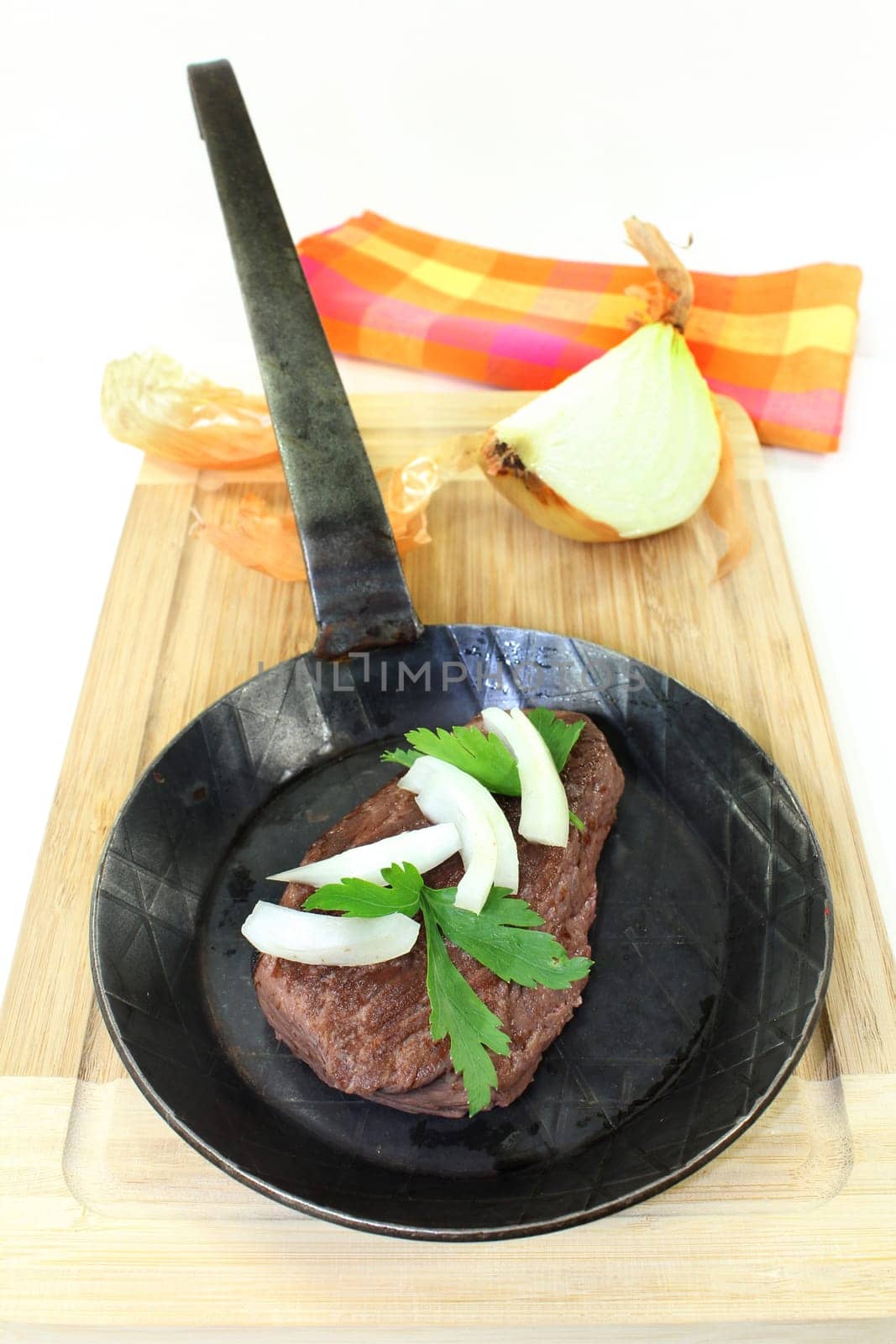a piece of ostrich meat in an iron pan