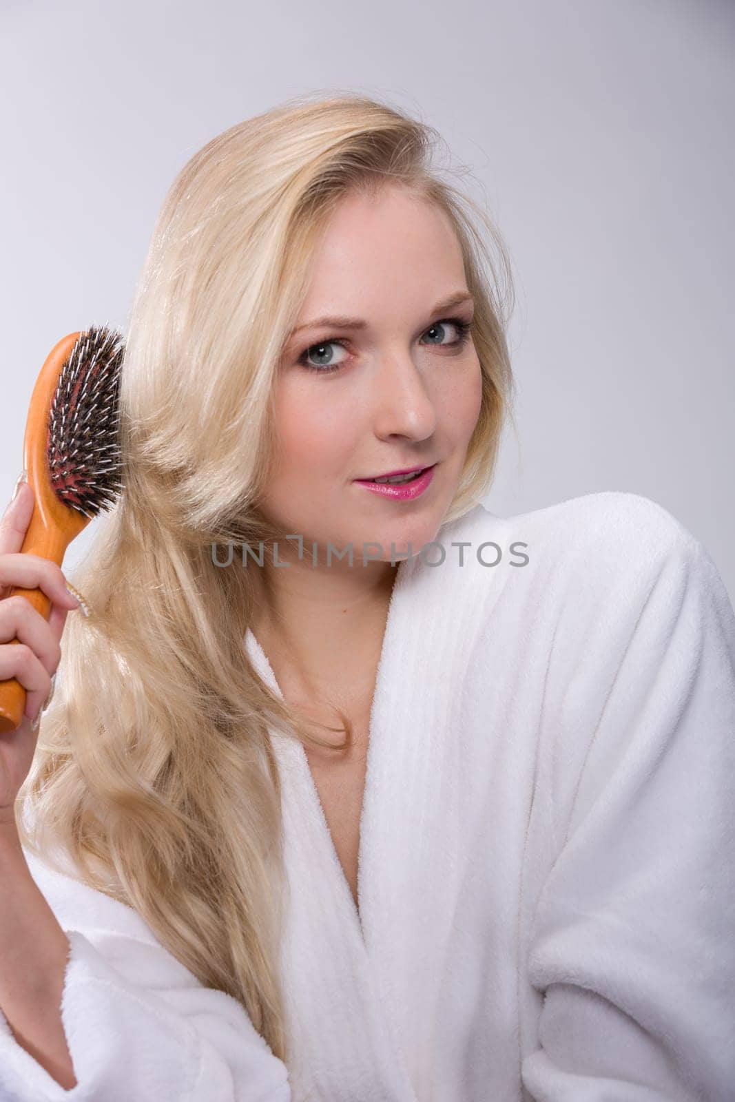 Girl brushes her blonde hair
