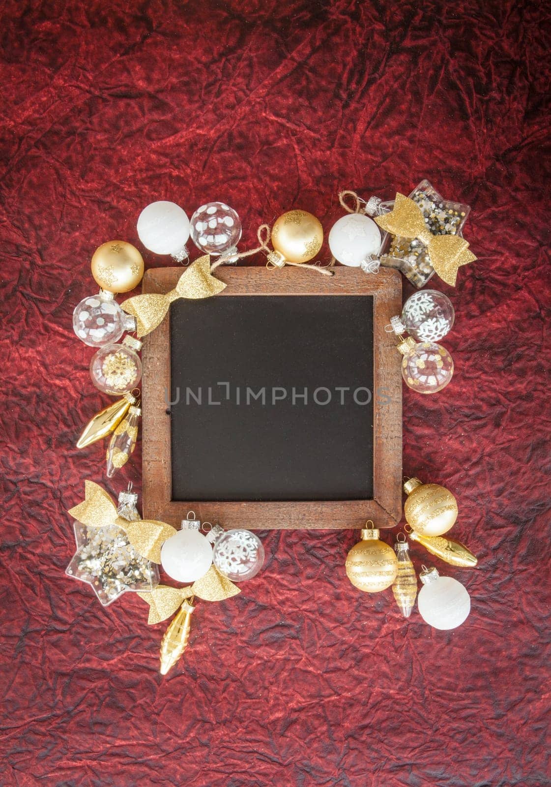 White and golden Christmas baubles on a dark red background