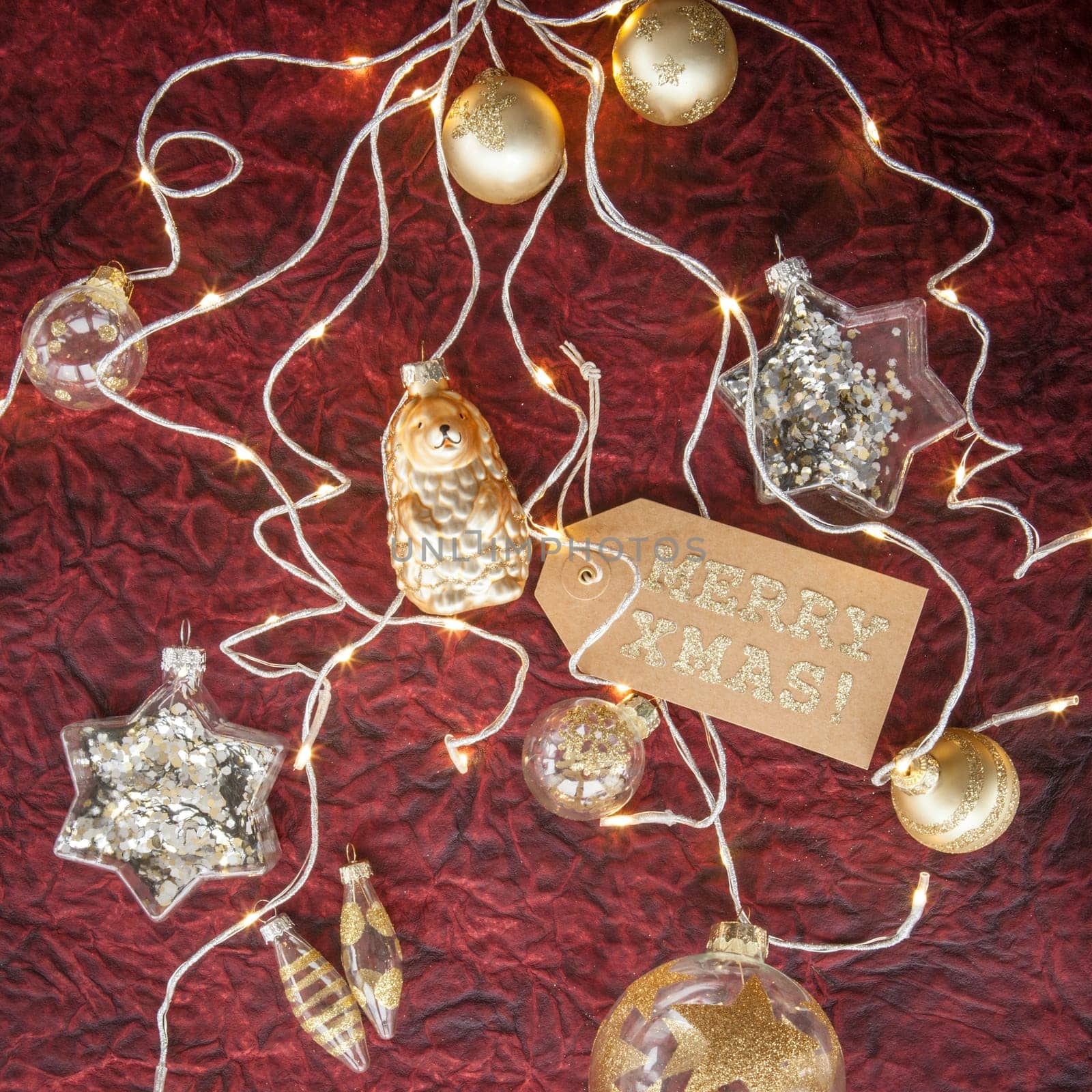 White and golden Christmas baubles on a dark red background