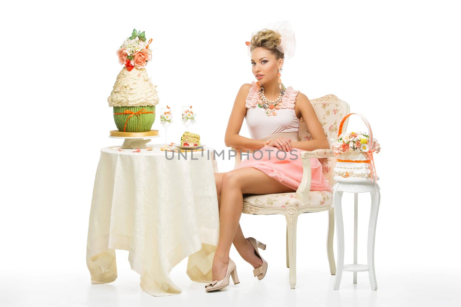 Young beautiful woman sitting behind table with wedding cake