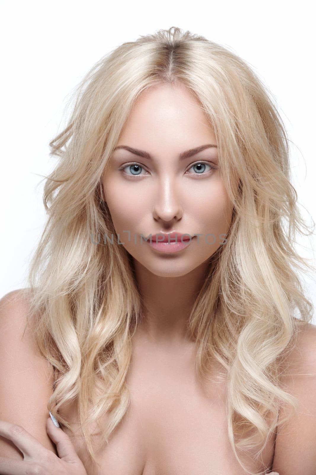 Beautiful young woman with perfect skin and wavy shiny hair isolated over white background. Beauty shot. Copy space.