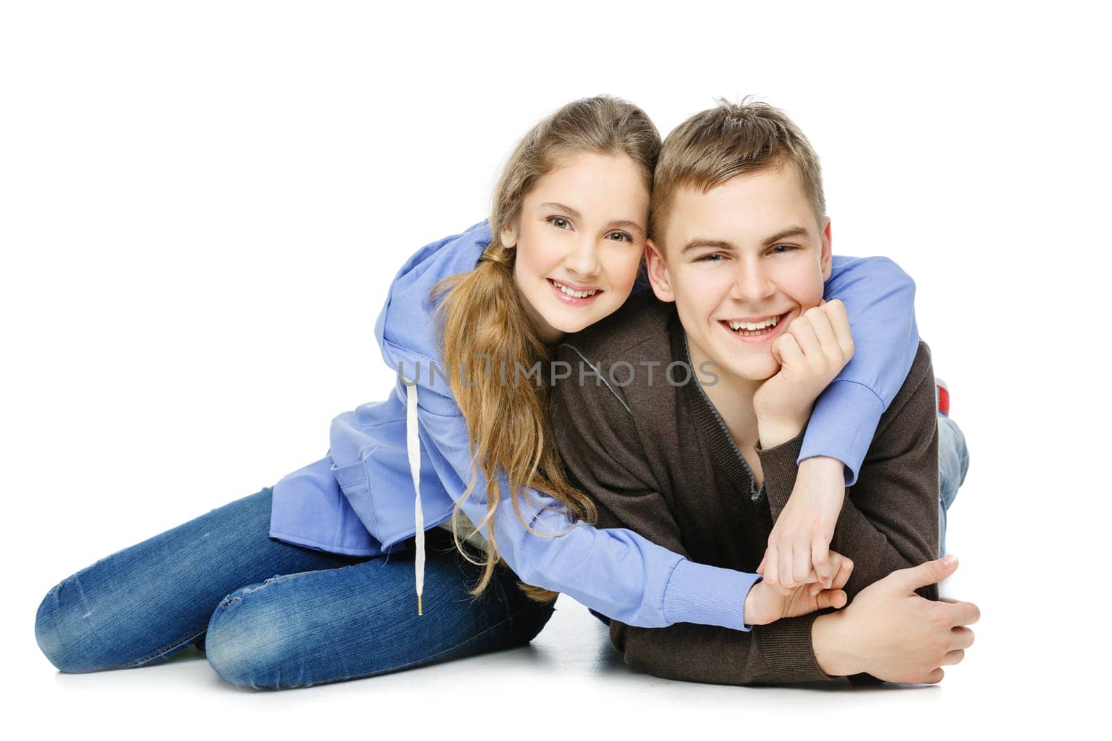 Beautiful teenage girl and boy in casual clothes sitting over white background. Isolated. Copy space.