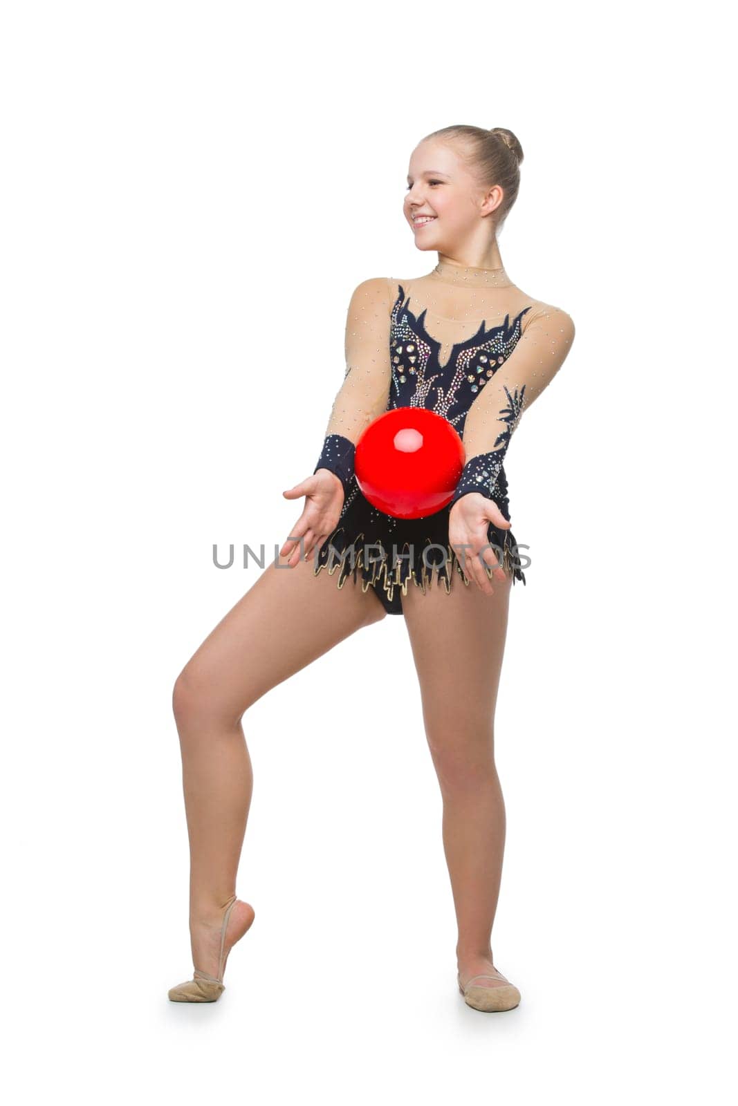 Gymnast girl in beautiful costume making jumping exercise with red ball. Isolated over white background. Copy space.