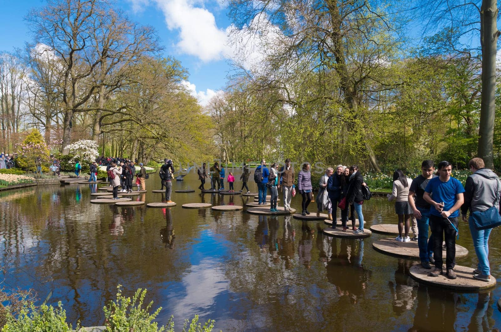 LISSE, NETHERLANDS - APRIL 17, 2016: Unknown tourists enjoying the water route in the famous keukenhof gardens in the netherlands