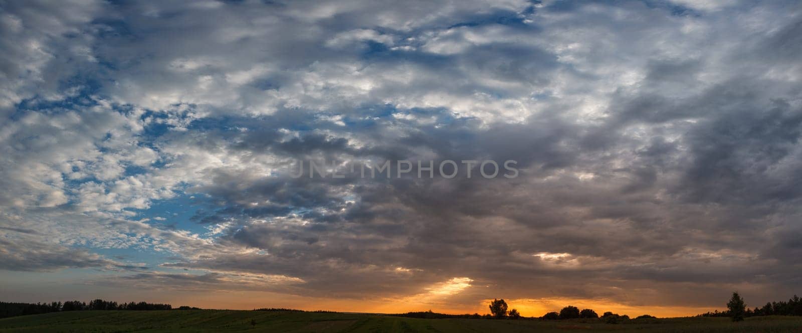 Beautiful dramatic sunset over the field with clouds
