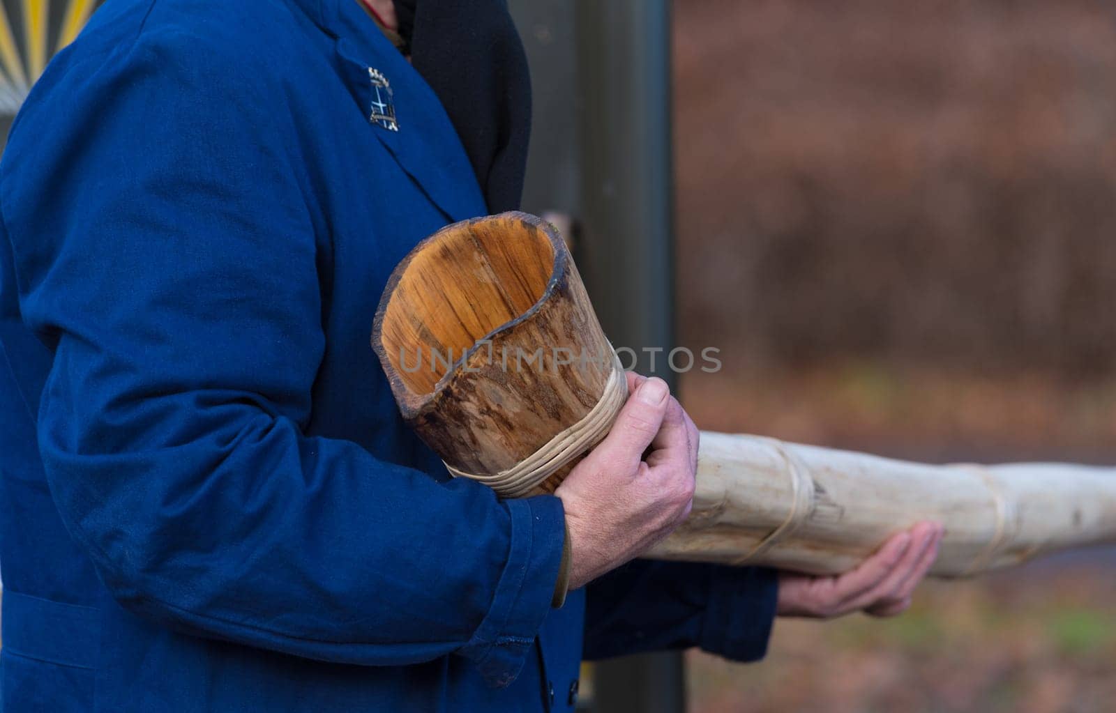 man holding the end of a traditional handmade horn in his hands. These horns a blown during the advent period in some eastern parts of the netherlands