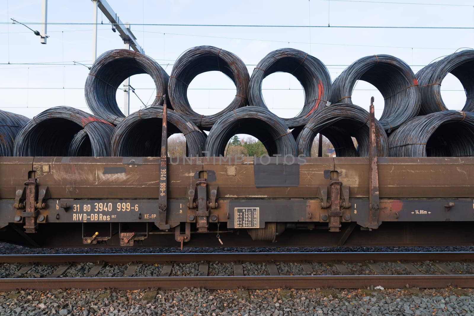 row of train cargo wagons with rolls of steel wire