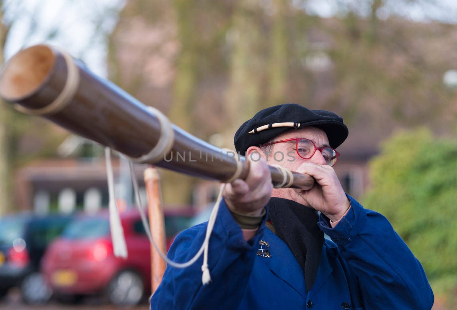OLDENZAAL, NETHERLANDS - NOVEMBER 27, 2016: Unknown man blowing a so called "midwinterhorn"", a traditional handmade wooden instument. It is used in the advent period in some eastern parts of the netherlands"