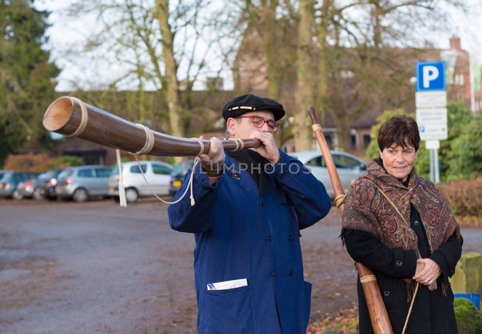 OLDENZAAL, NETHERLANDS - NOVEMBER 27, 2016: Unknown man blowing a so called "midwinterhorn"", a traditional handmade wooden instument. It is used in the advent period in some eastern parts of the netherlands"