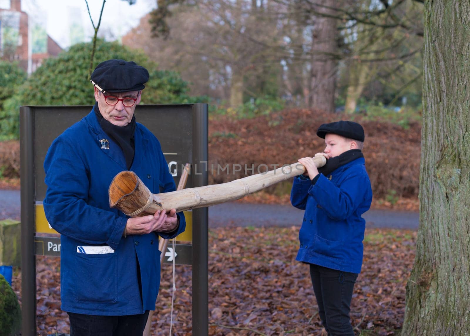 OLDENZAAL, NETHERLANDS - NOVEMBER 27, 2016: Unknown young boy blowing a so called "midwinterhorn"", a traditional handmade wooden instument. It is used in the advent period in some eastern parts of the netherlands"