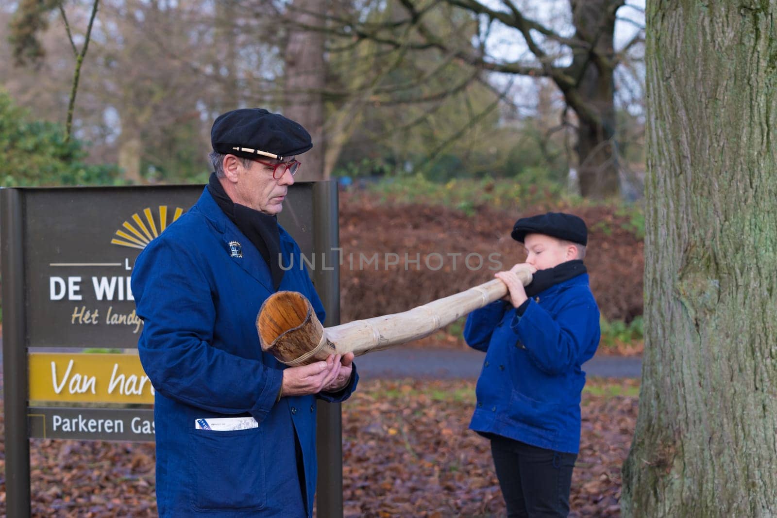 OLDENZAAL, NETHERLANDS - NOVEMBER 27, 2016: Unknown young boy blowing a so called "midwinterhorn"", a traditional handmade wooden instument. It is used in the advent period in some eastern parts of the netherlands"