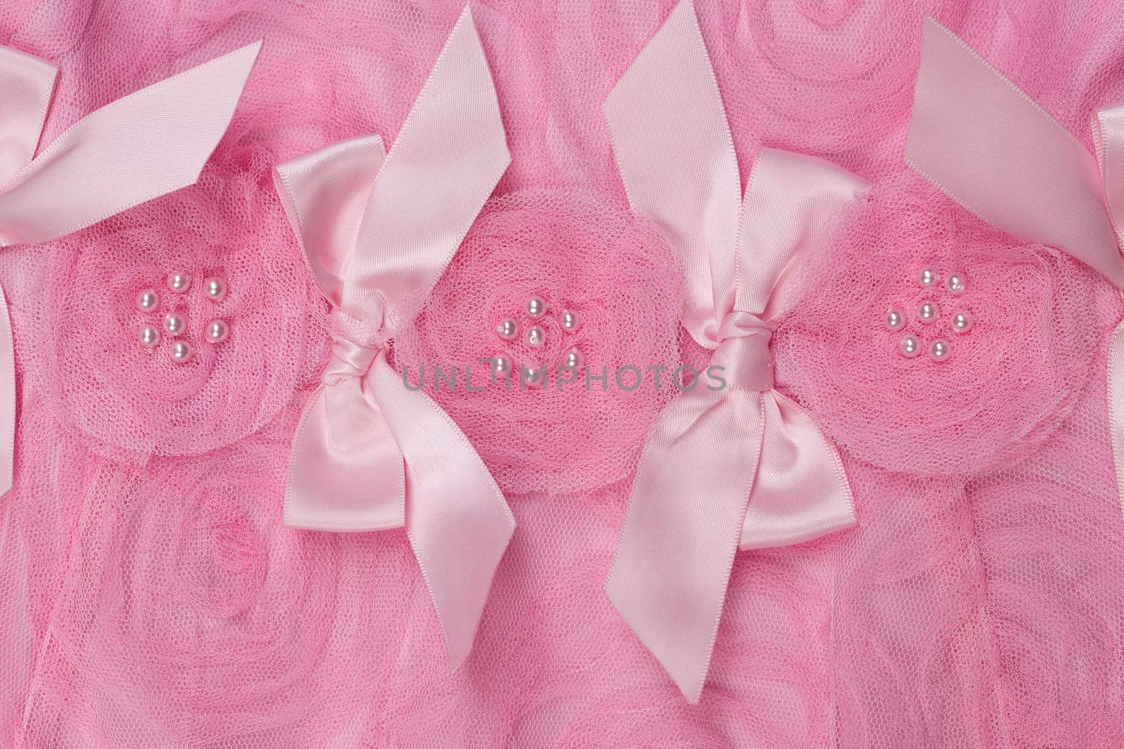 Background of pink satin fabric in the form of roses close-up.