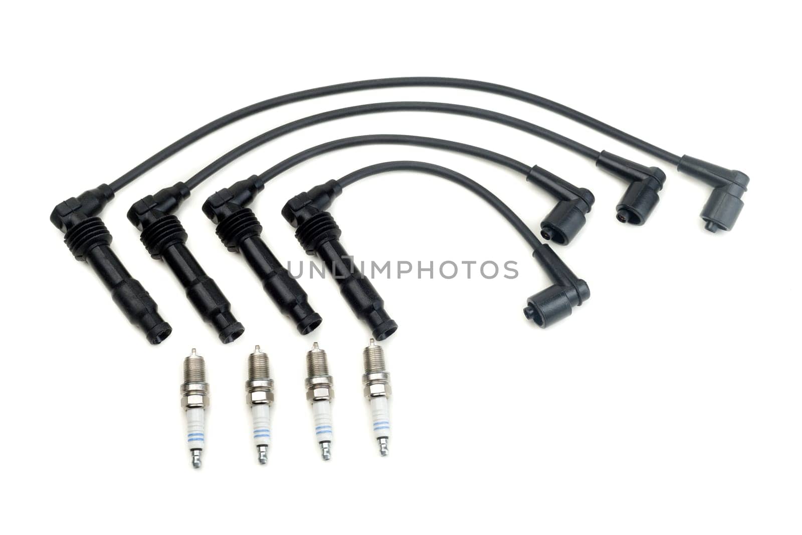 Four spark plugs and a set of high-voltage wires. Isolate on white.