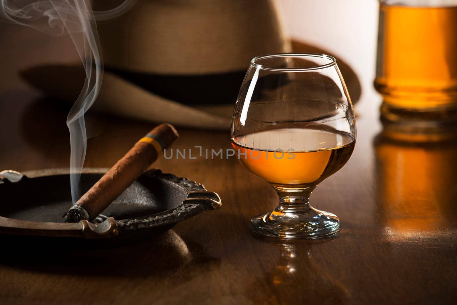 Whiskey, cognac, brandy and cigar on wooden background