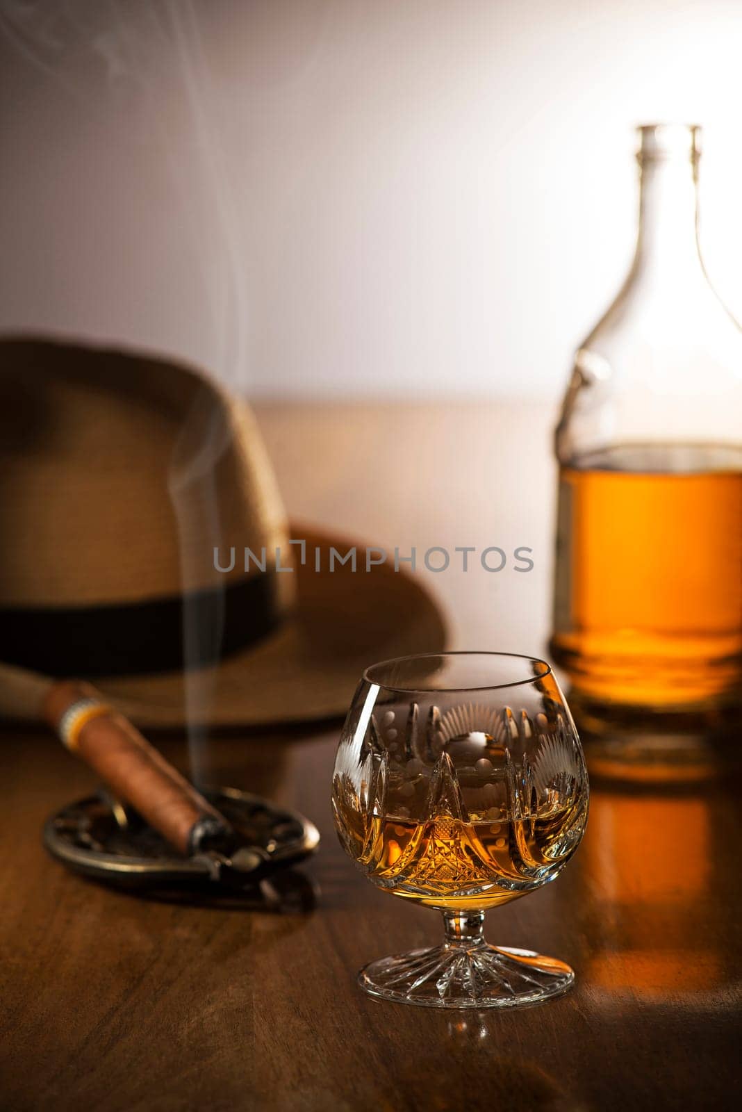 Whiskey, cognac, brandy and cigar on wooden background