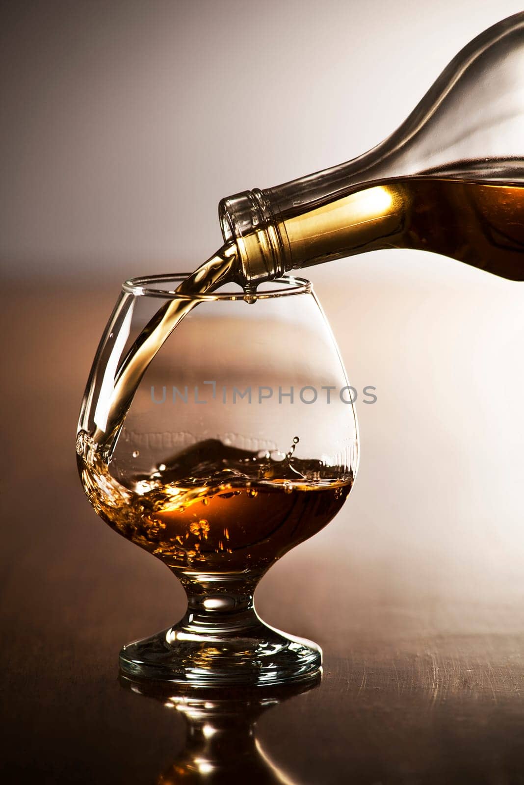 Pouring alcohol drink into glass close up shoot