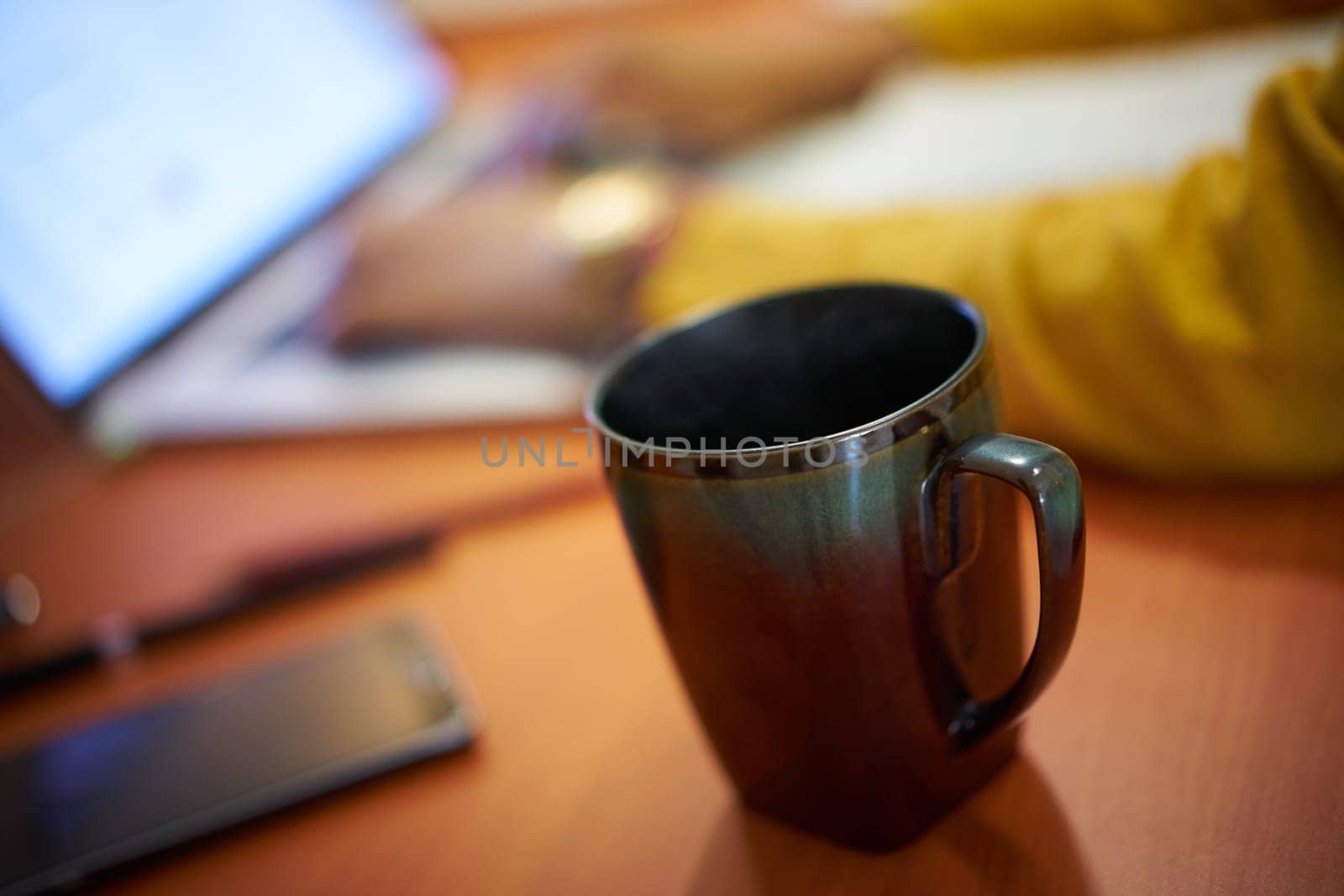 Woman drinking coffee while working with laptop pc at home. Girl studying late at night. College student doing education homework for school