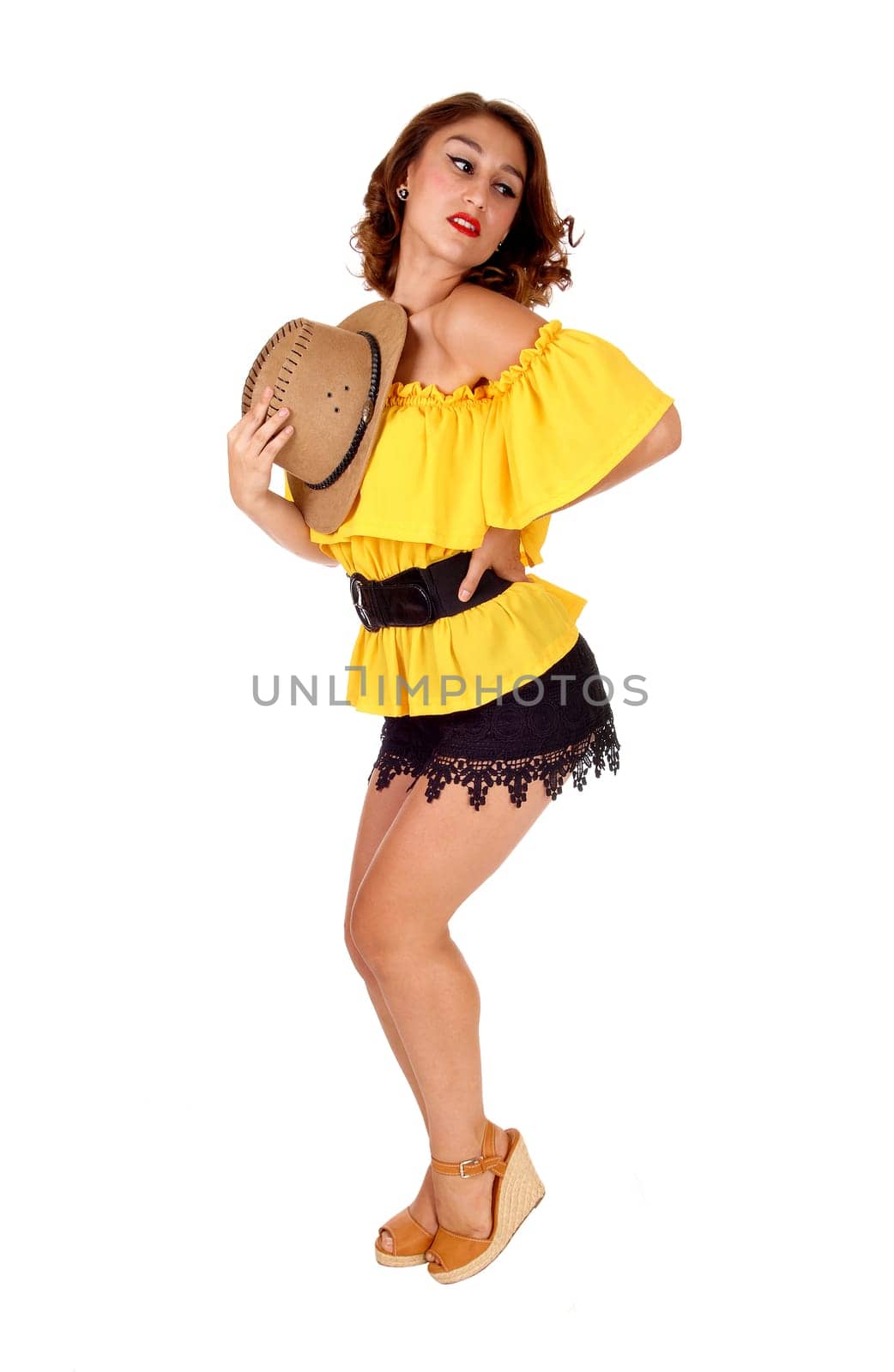 A lovely young woman posing in black shorts and yellow blouse with.a cowboy hat, isolated for white background..