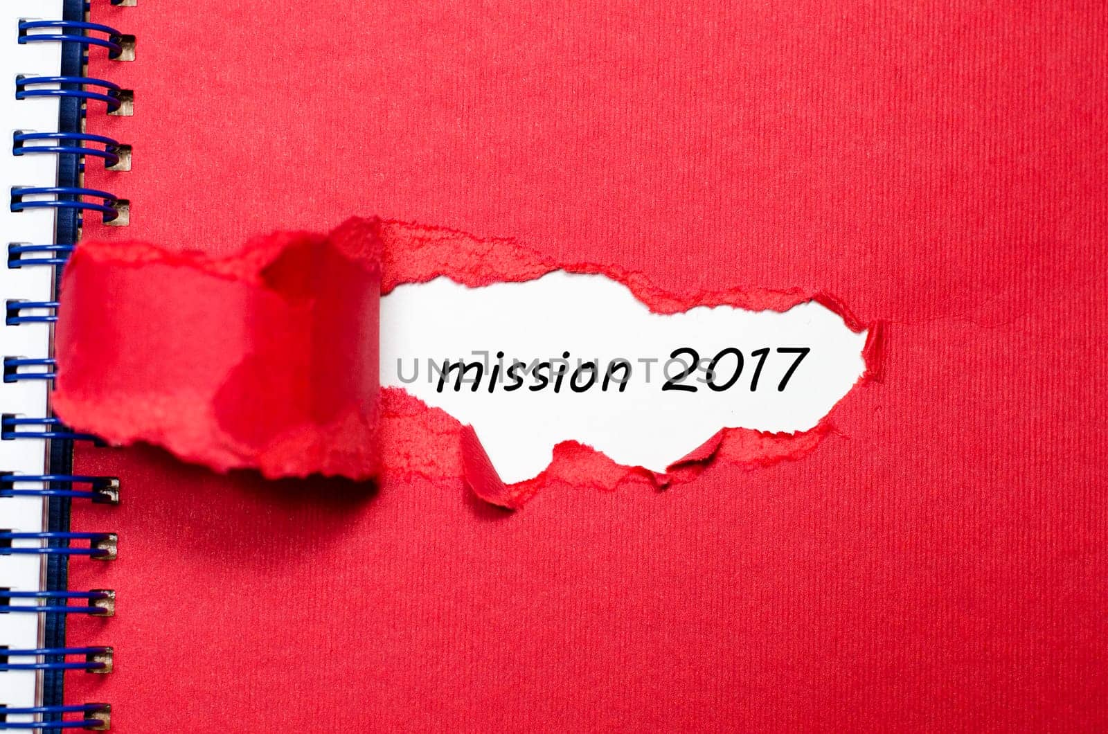 The word mission 2017 appearing behind torn paper
