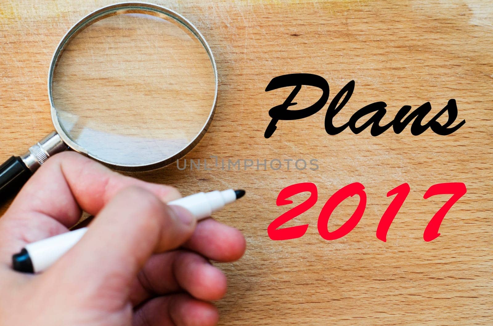 Human hand over wooden background and plans 2017 text concept