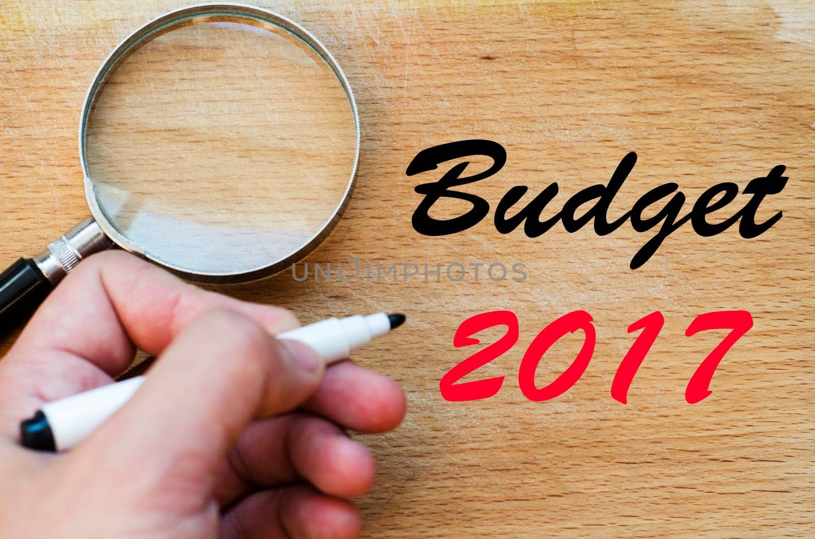 Human hand over wooden background and budget 2017 text concept