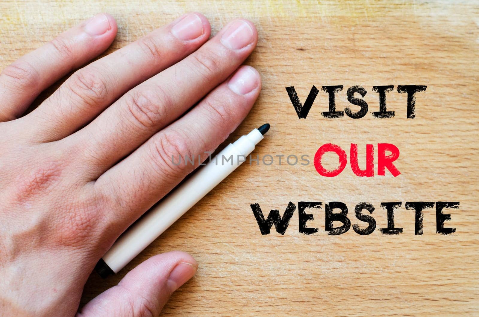 Human hand over wooden background and visit our website text concept