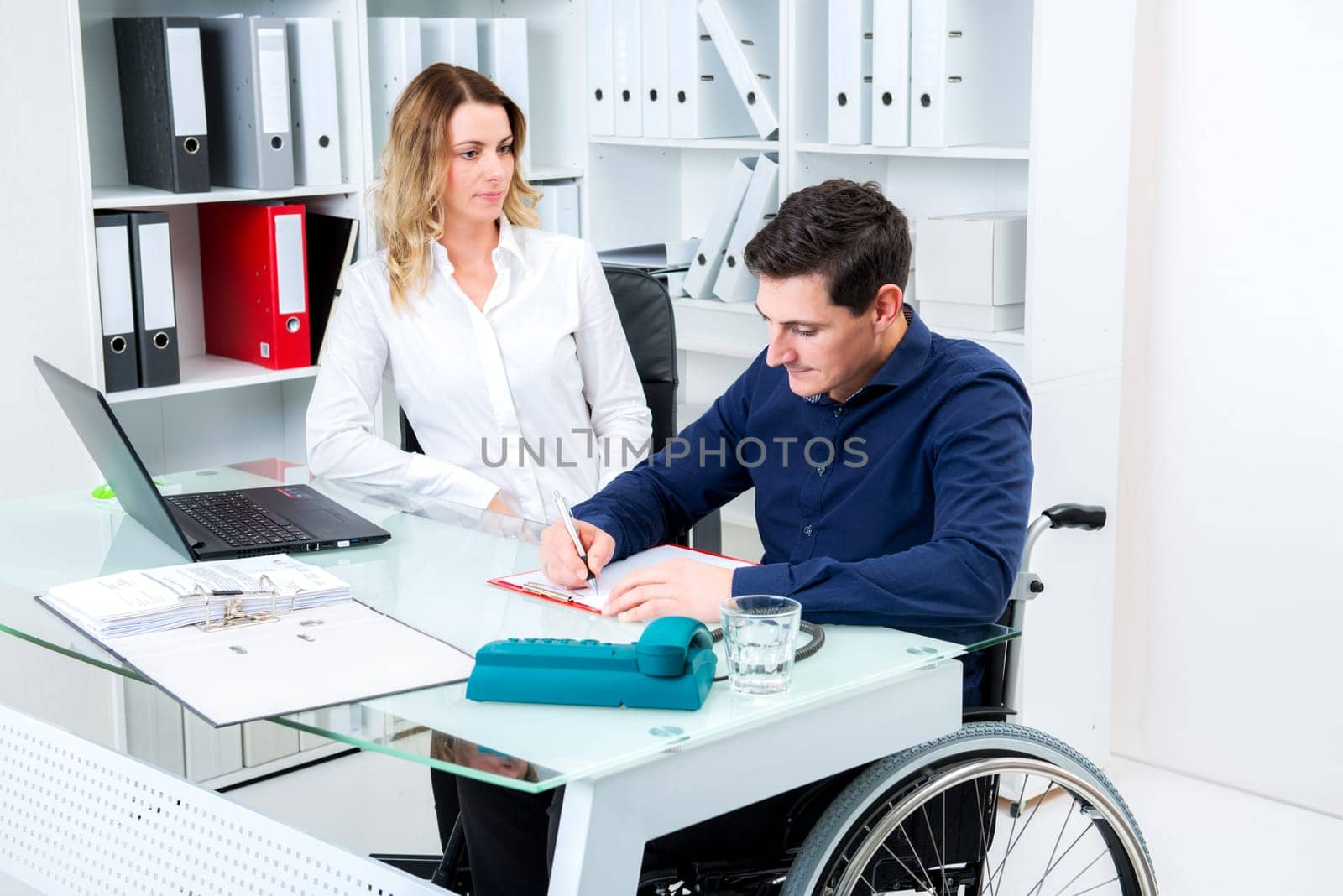 disabled businessman in wheelchair and his female colleague