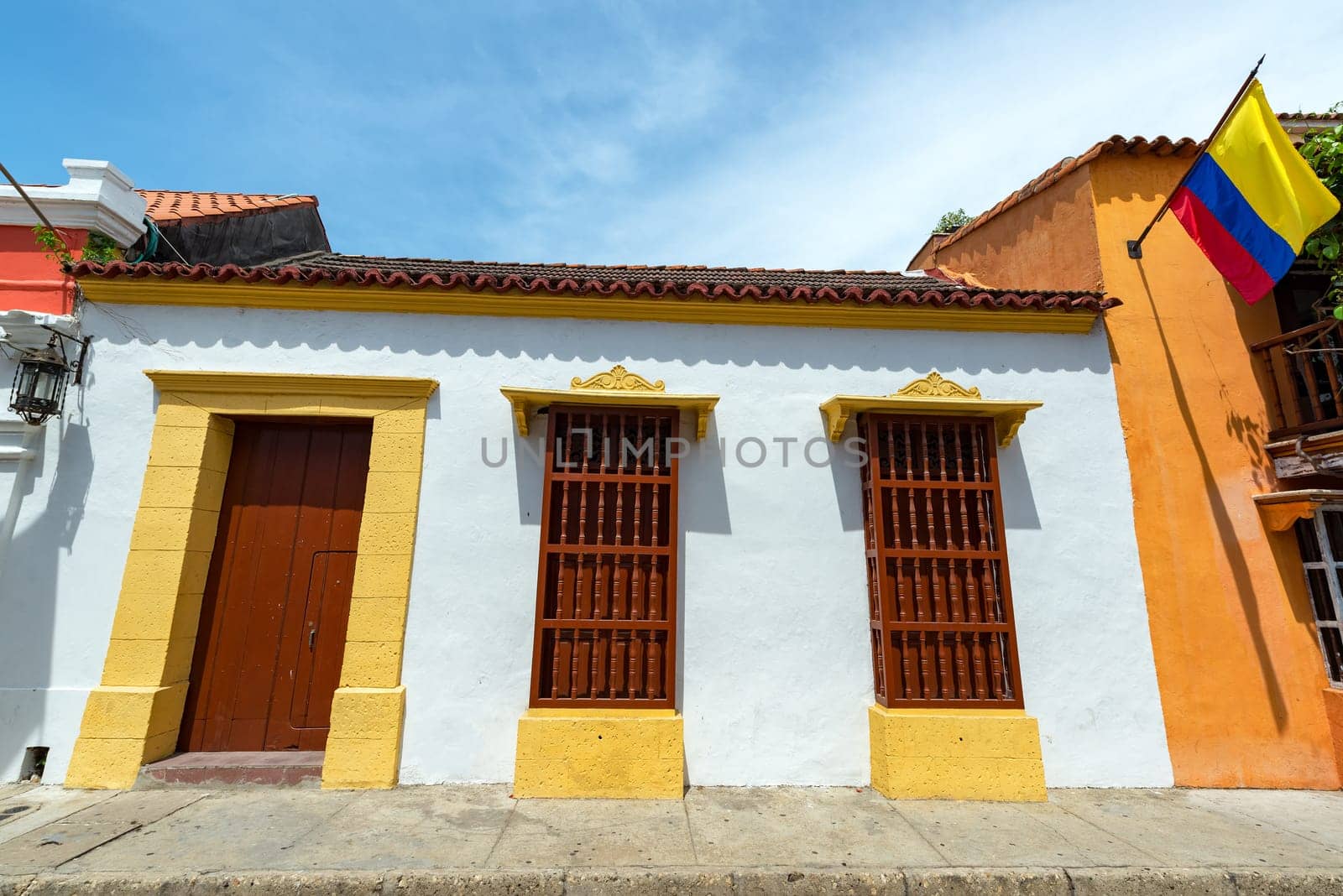 White colonial architecture with a Colombian flag visible in Cartagena, Colombia
