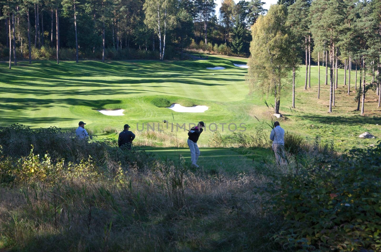 four golf player on hills gollf club have a competition