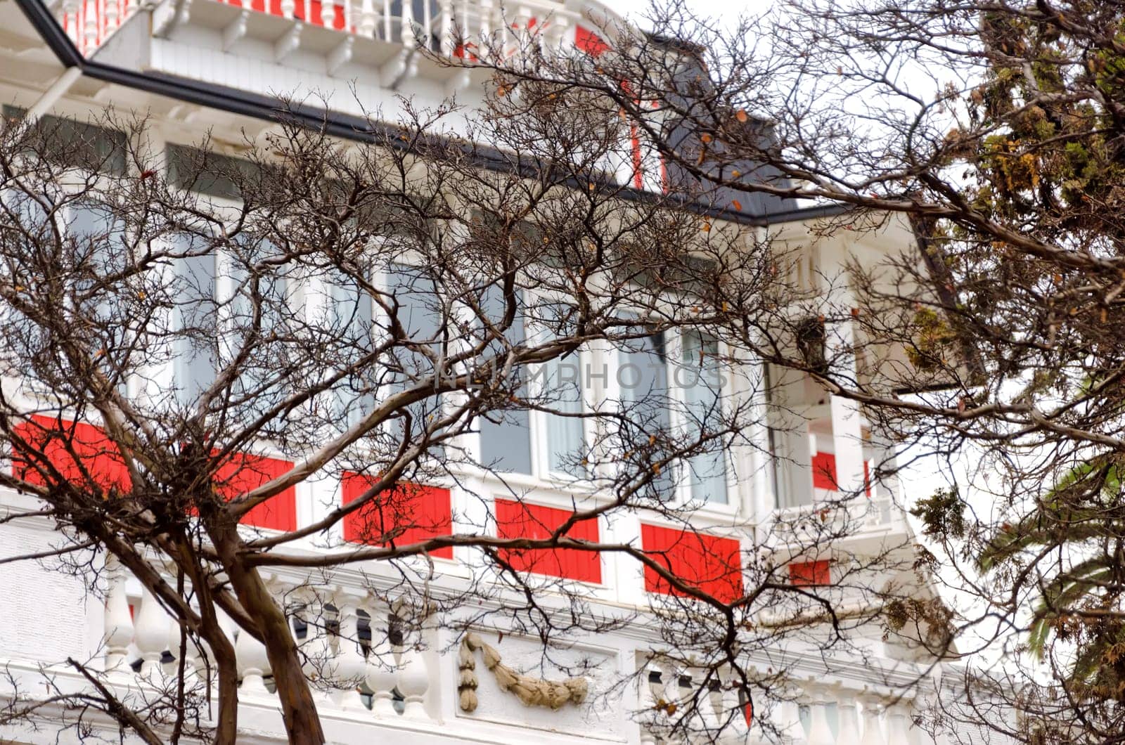 An elegant white house with brilliant red trim looks out over the harbor in Valparaiso, Chile