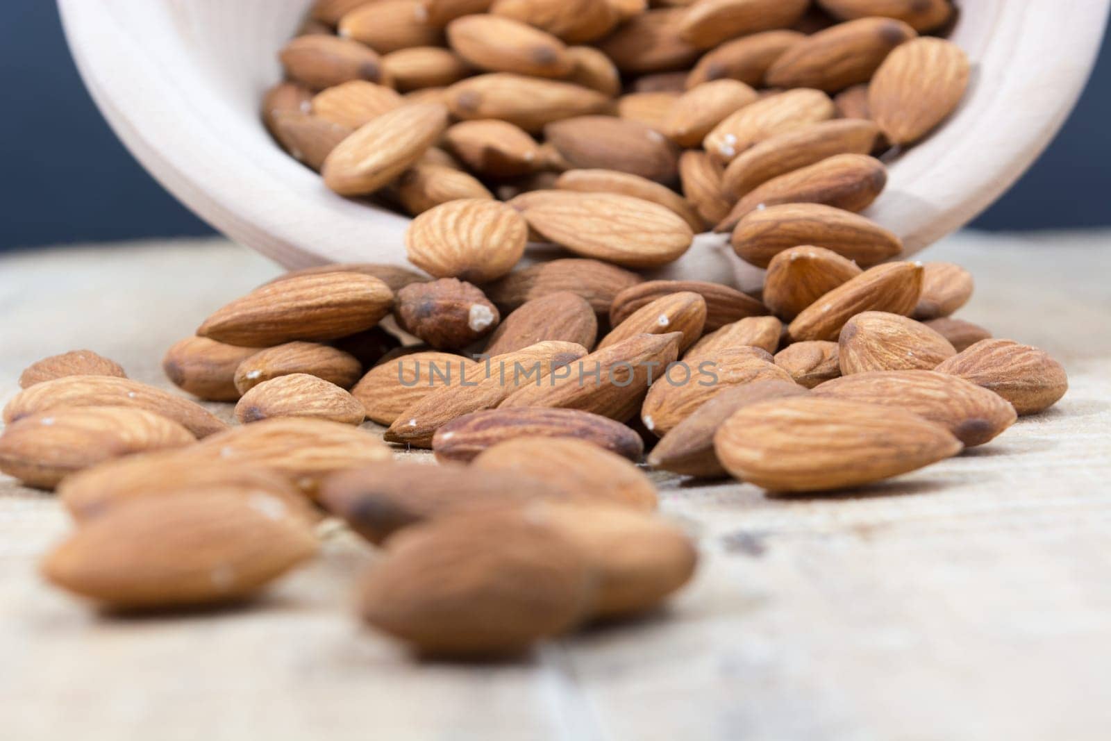 Spilled almonds out of the bowl on the table
